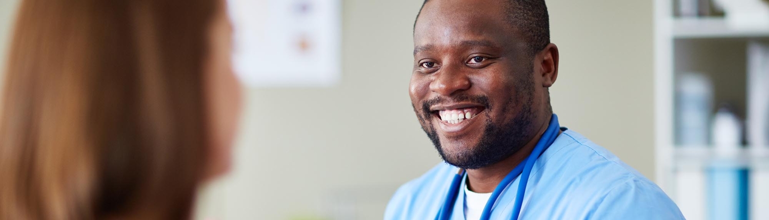 Side view of a male nurse smiling at a patient